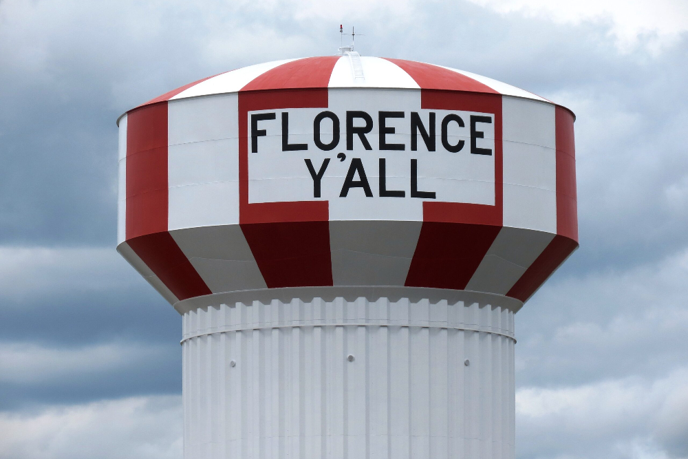 Florence-Kentucky | Helmer Somers Law Water tower with red and white stripes and the phrase FLORENCE Y'ALL on the tank against a cloudy sky