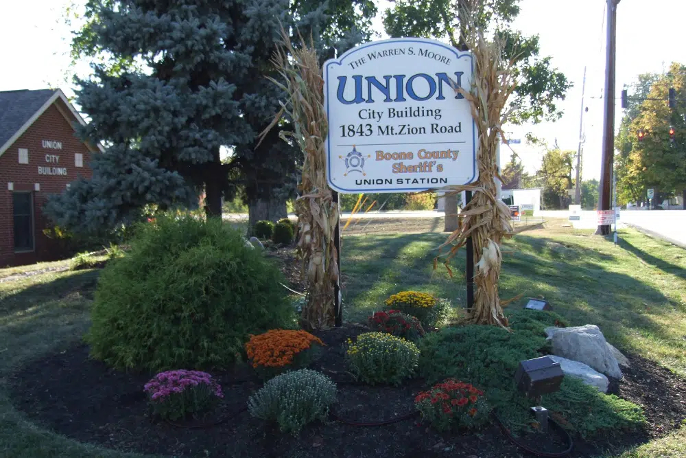 Sign for Union City Building at 1843 Mt. Zion Road, with corn stalk decorations and colorful flower bed in front.
